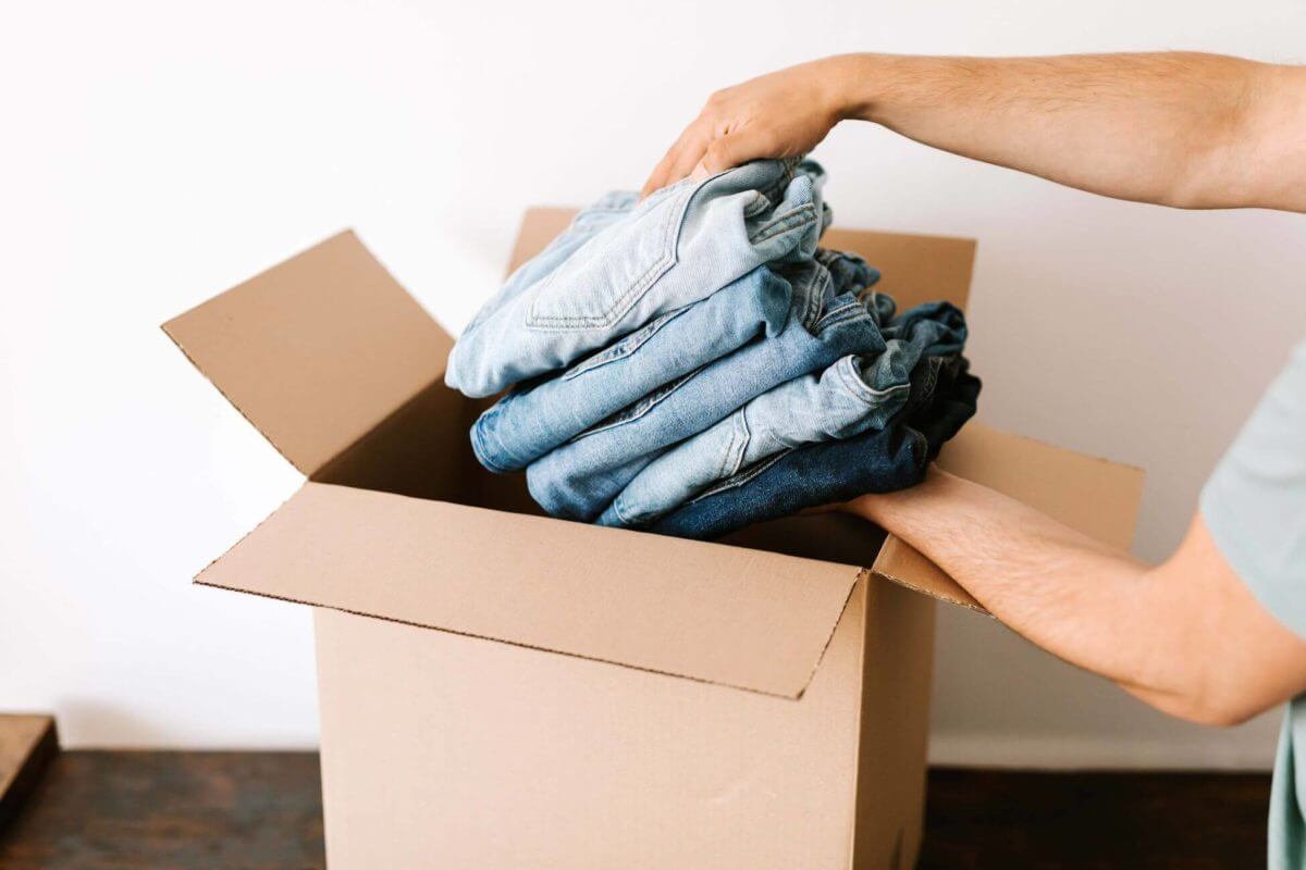 person putting jeans in the box