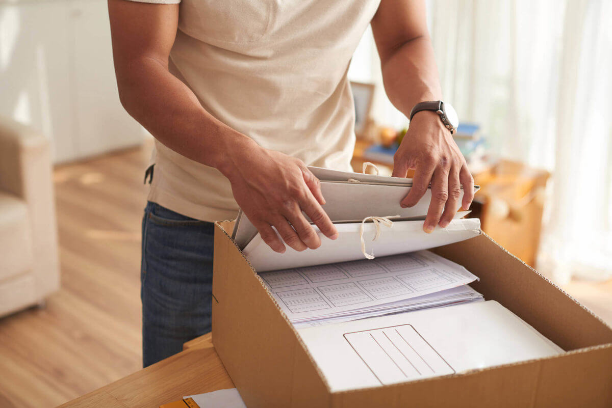 A man getting through documents packed in a box and prepare for long distance moving
