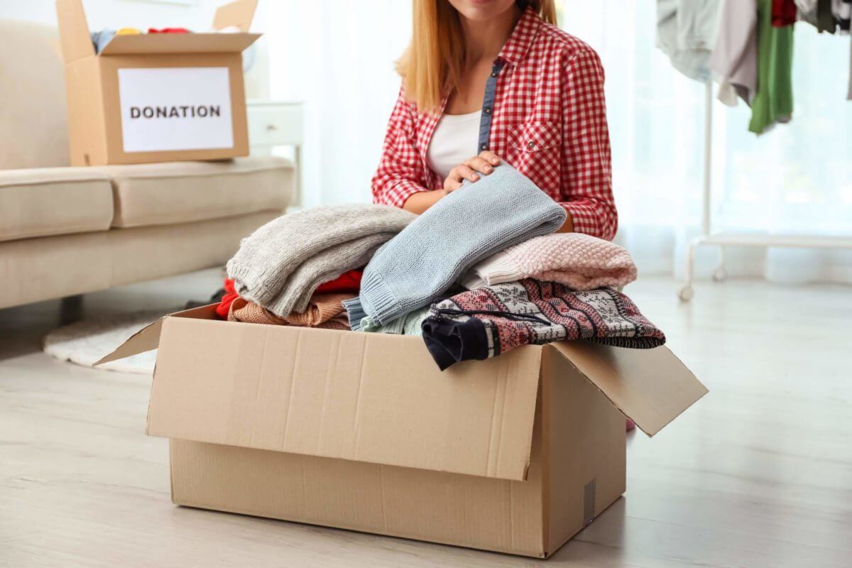 person putting clothes in boxes and getting ready for long distance moving