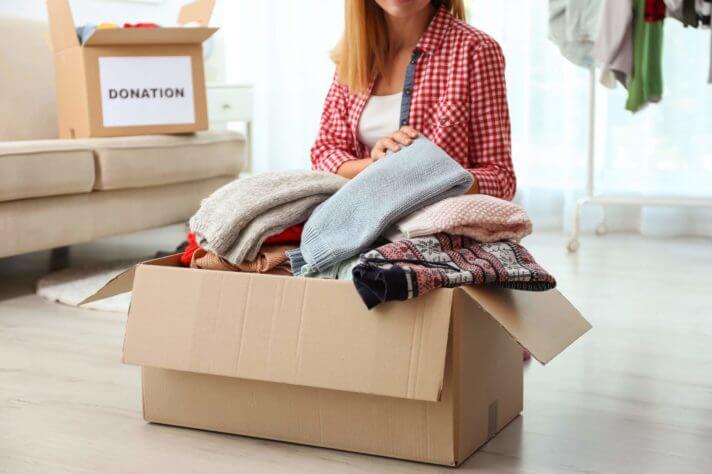 person putting clothes in boxes and getting ready for long distance moving