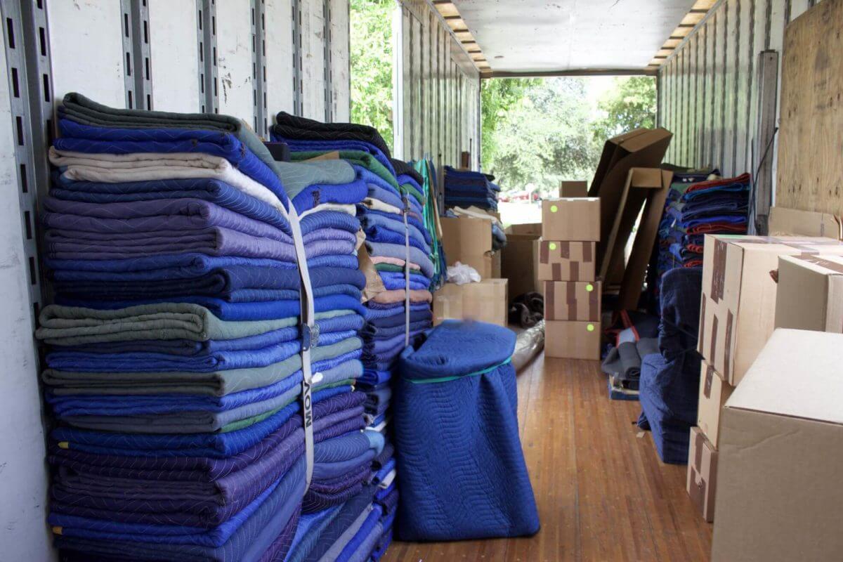 Piles of moving blankets and boxes in a relocation truck