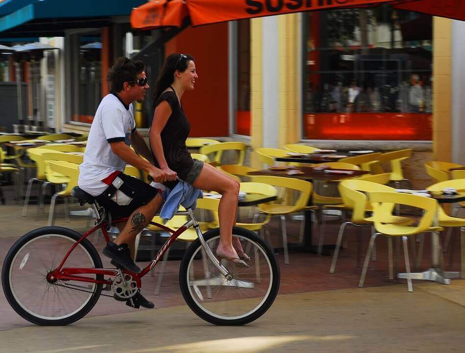 A man riding a bicycle with a woman