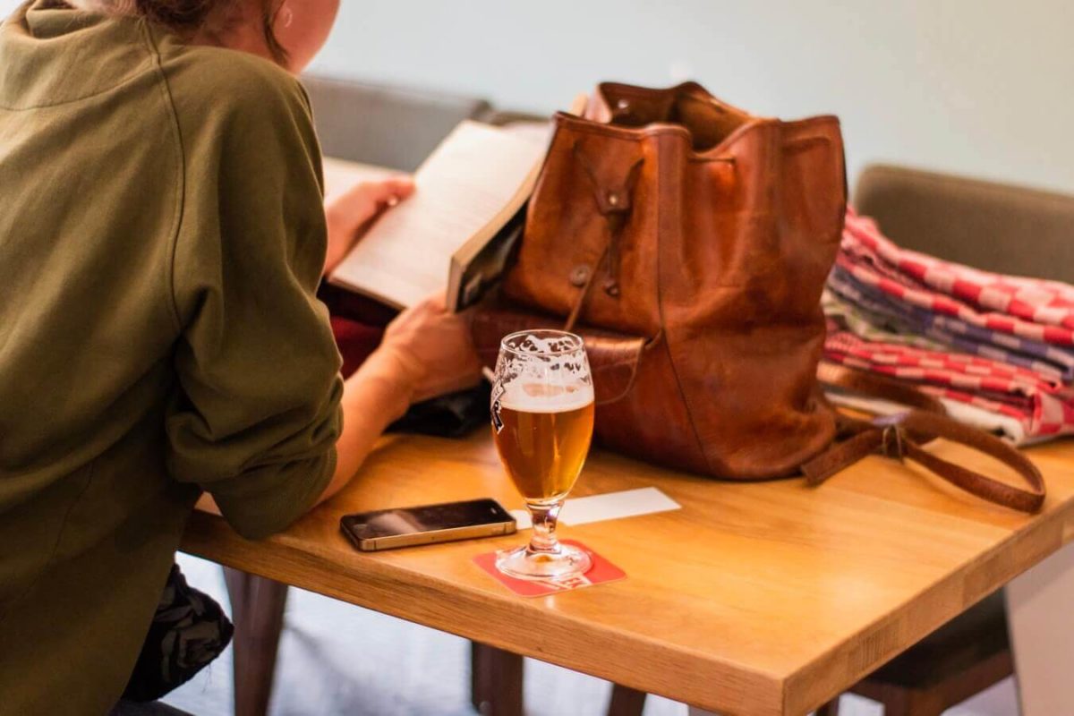 girl sitting in a pub reading a book