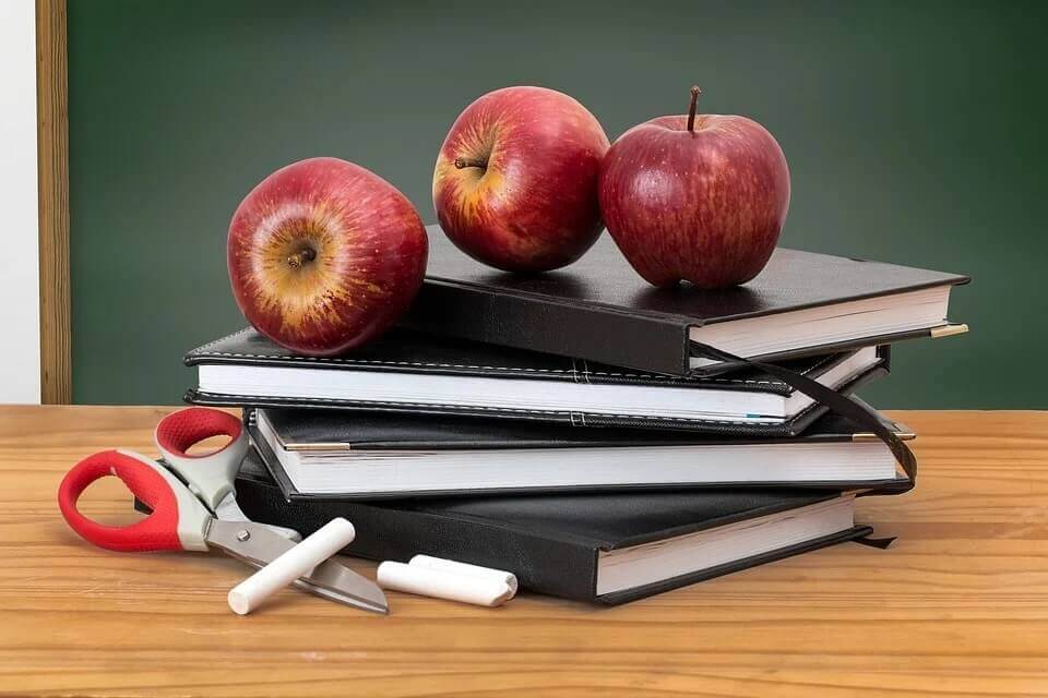 stack of books and two apples
