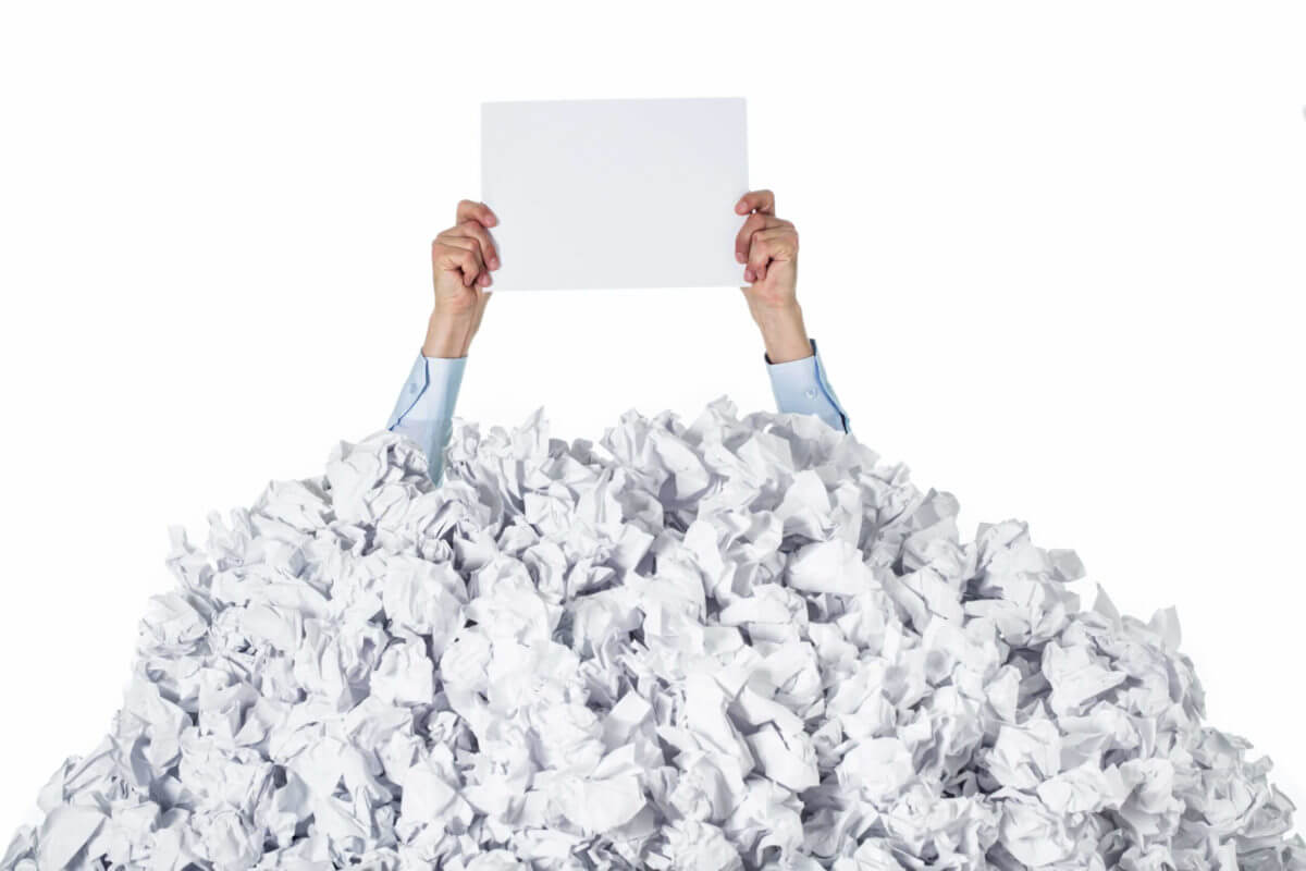 person covered with pile of papers while sorting them out for long distance moving