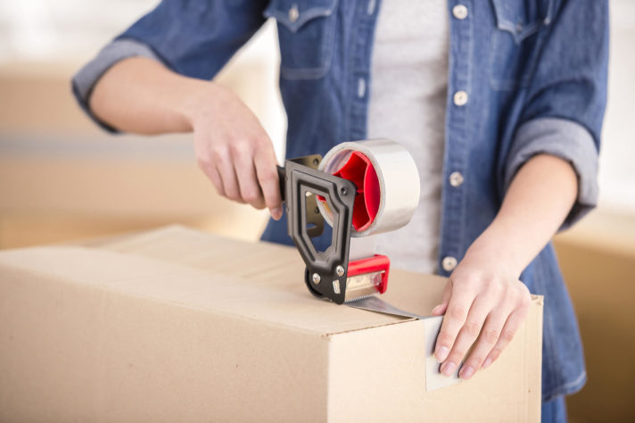 Woman duct-taping a box