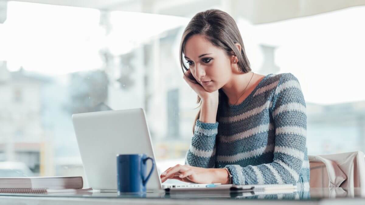 A girl looking at a laptop at home to sign the application for apartments