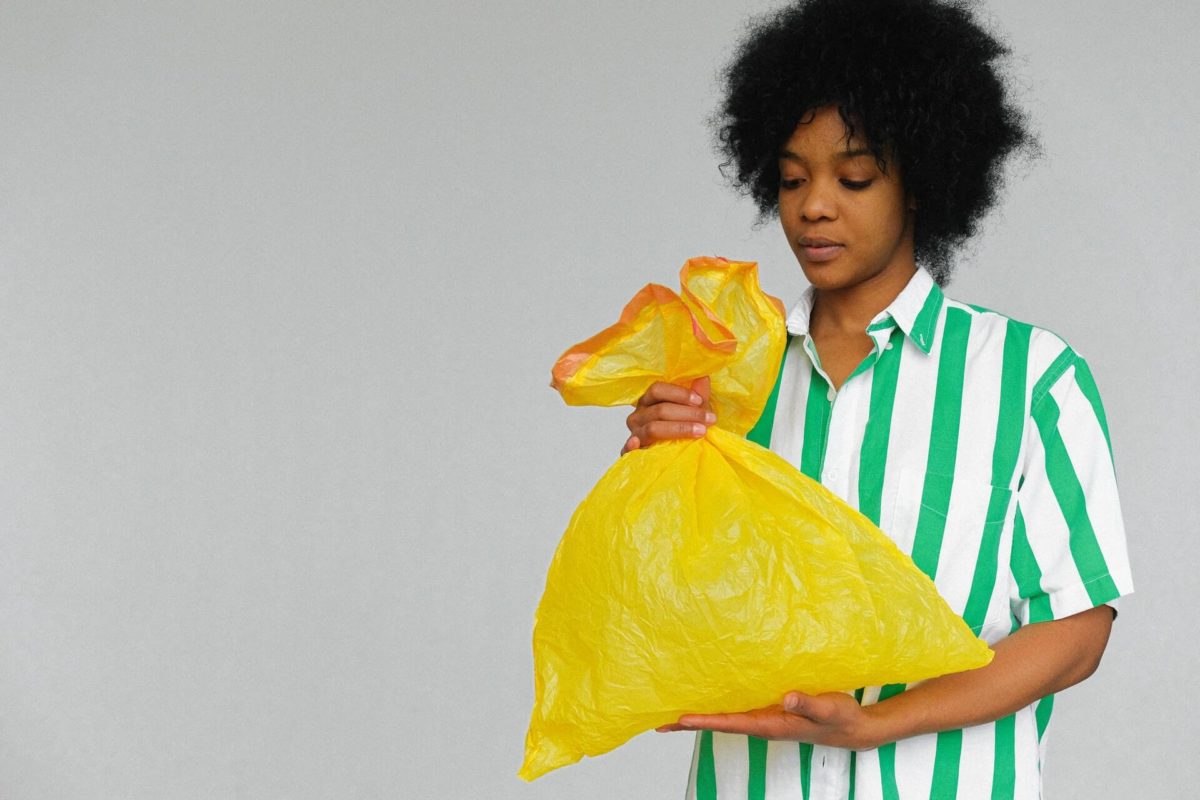 A woman holding a garbage bag