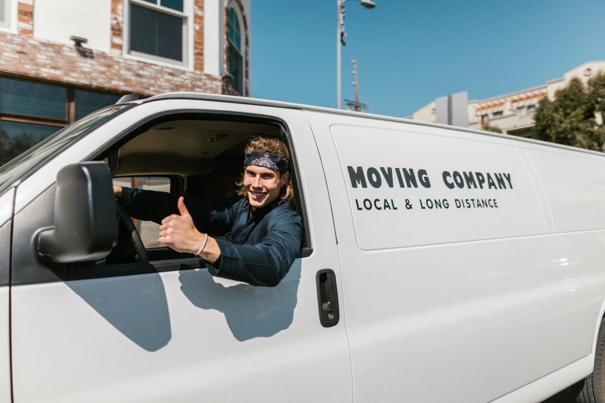 A mover in a cross-country moving truck showing thumbs up