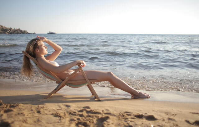 Girl sitting on a beach after a long-distance moving