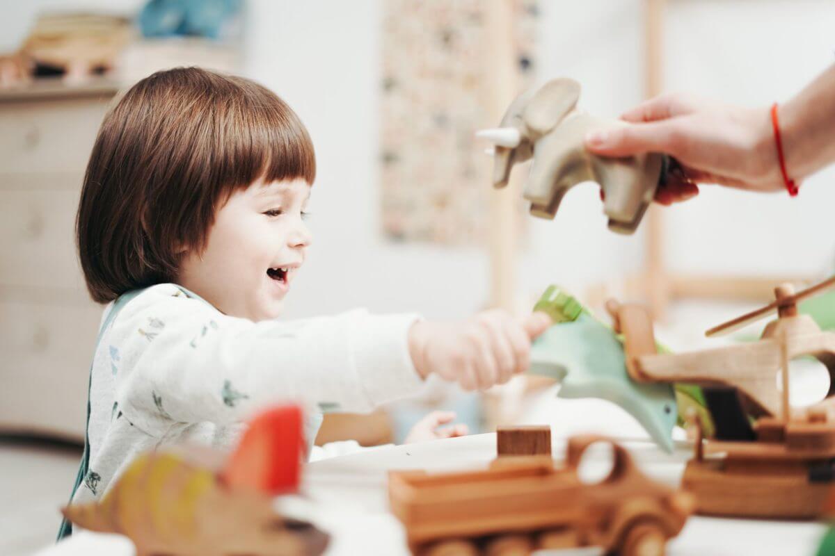 Child is playing with wooden toys after cross-coutnry moving
