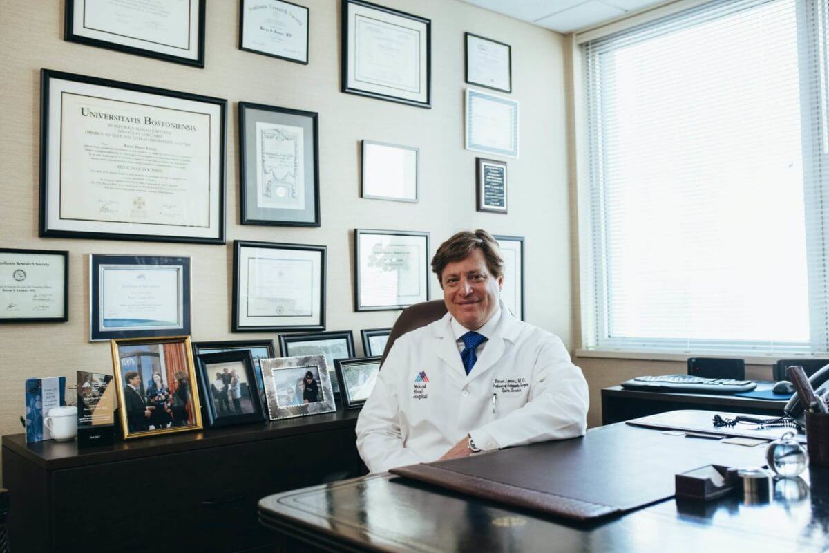 A physician with diplomas on the wall