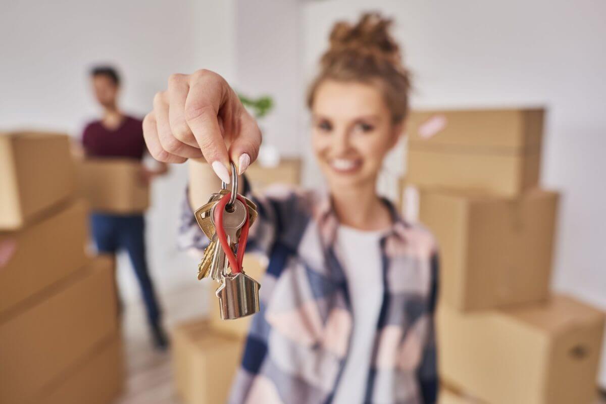 A girl holding house keys while waiting for long-distance movers