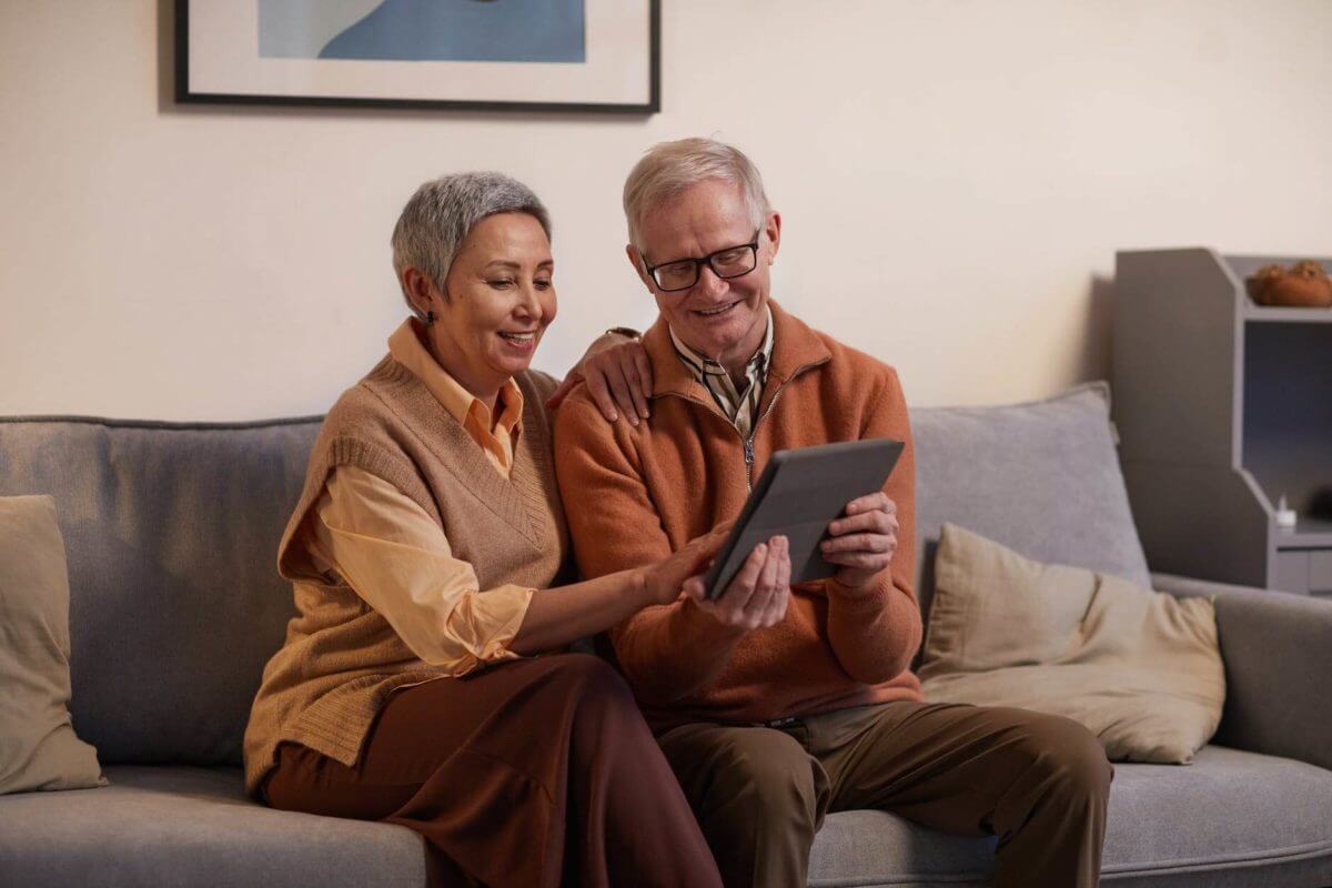 an older couple talking with their family on a tablet after cross-country moving