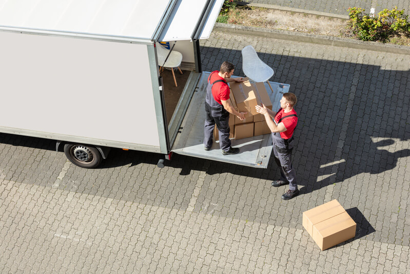 A long-distance moving company loading furniture on a truck