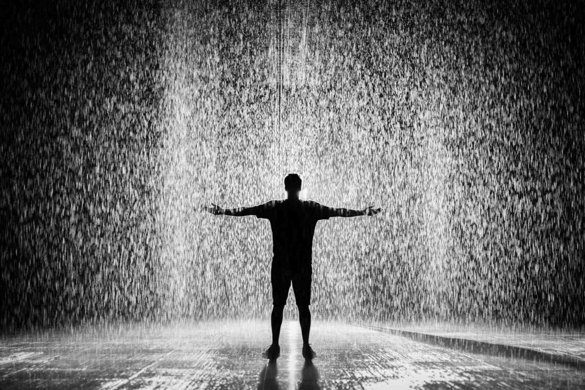 Man standing under the rain after long-distance moving