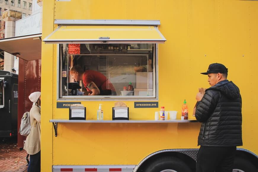 person eating in front of a food truck