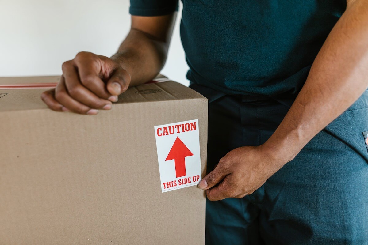 A professional cross-country mover is labeling the box