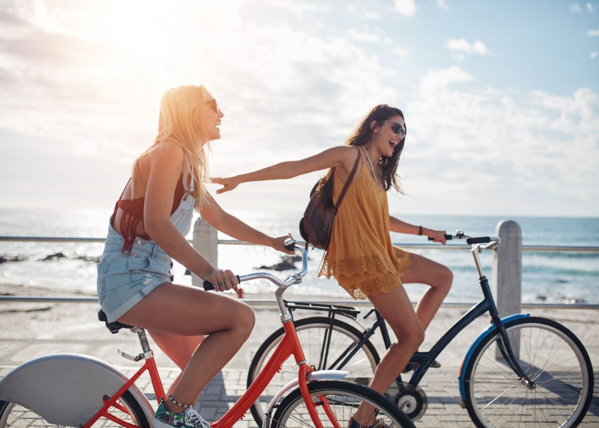 two girls cycling and smiling