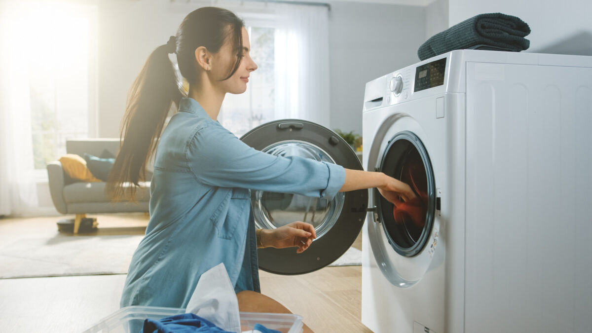 Woman removing stuff from the washer before long-distance moving