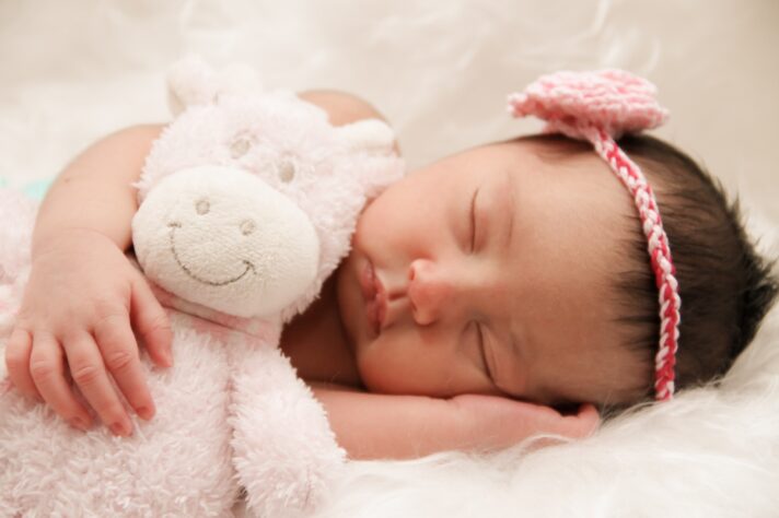A baby sleeping with a plush toy during long-distance moving