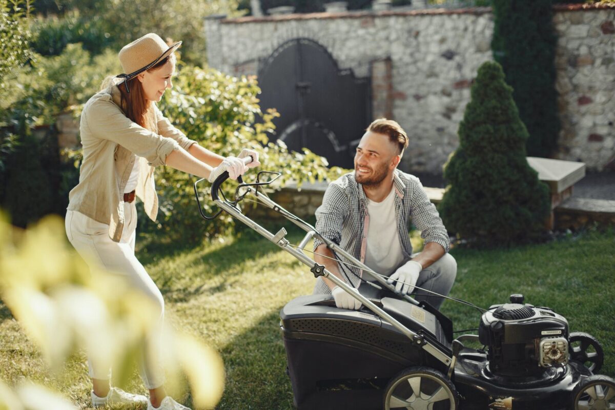 A man and a woman using a lawn mower