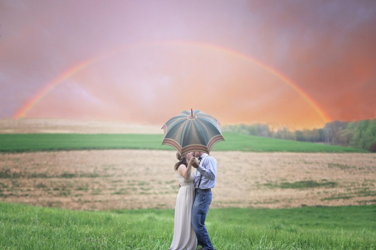 A couple kissing under an umbrella