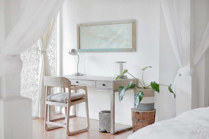 A small room with a desk, chair, and a curtain next to the bed