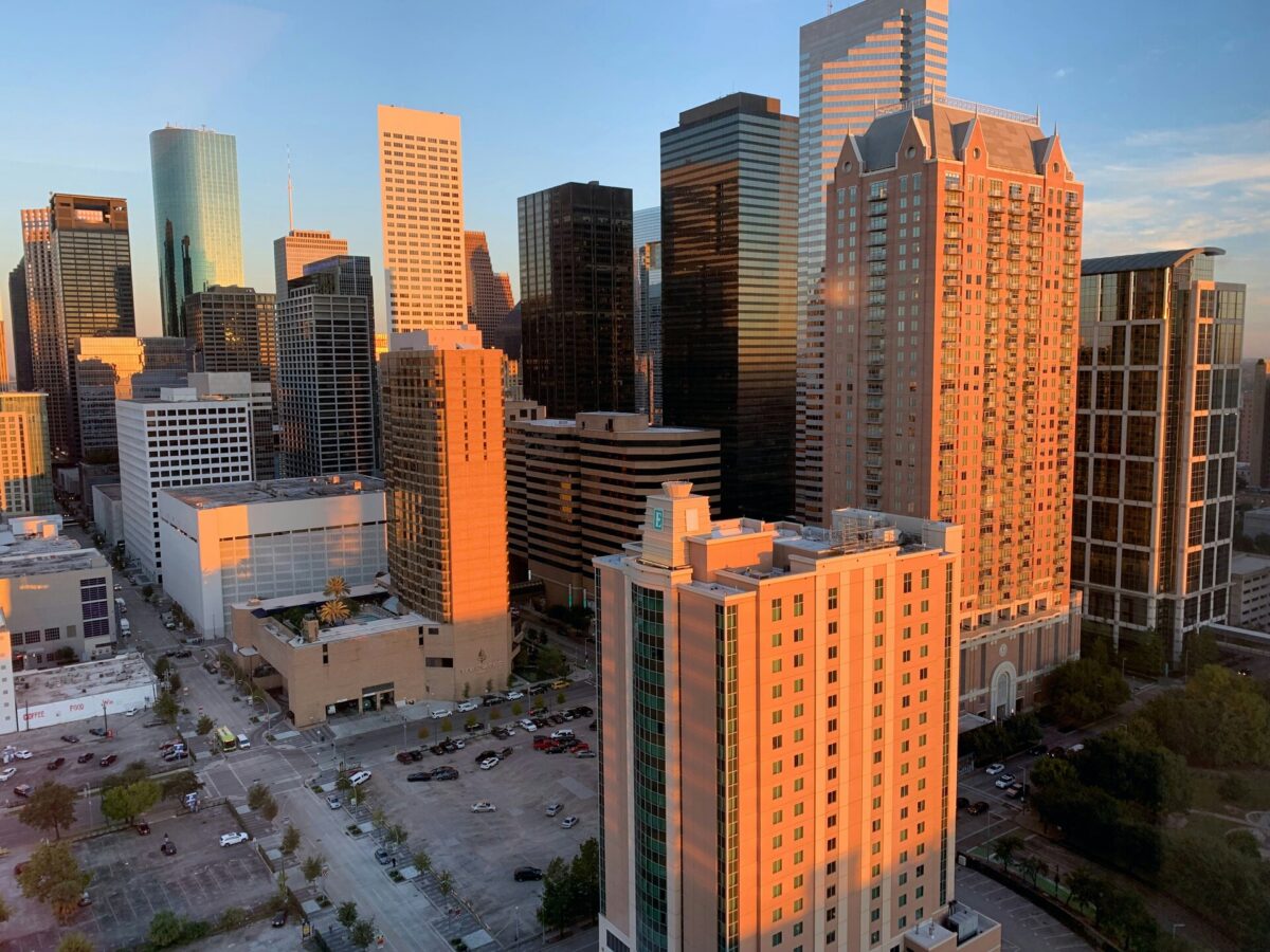 Magnificent skyscrapers in downtown Houston, Texas, beautifully lit by an orange sunset.