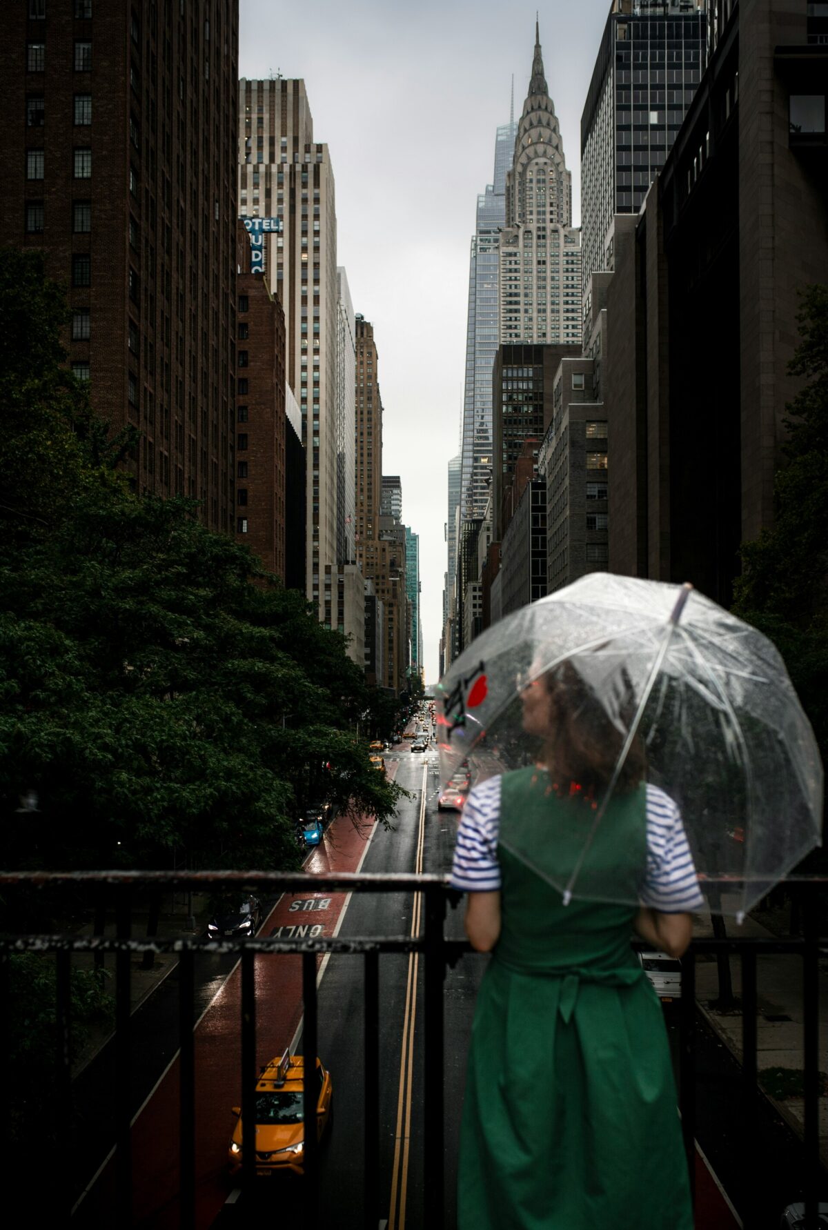 Woman in an elegant green dress holding an umbrella.
